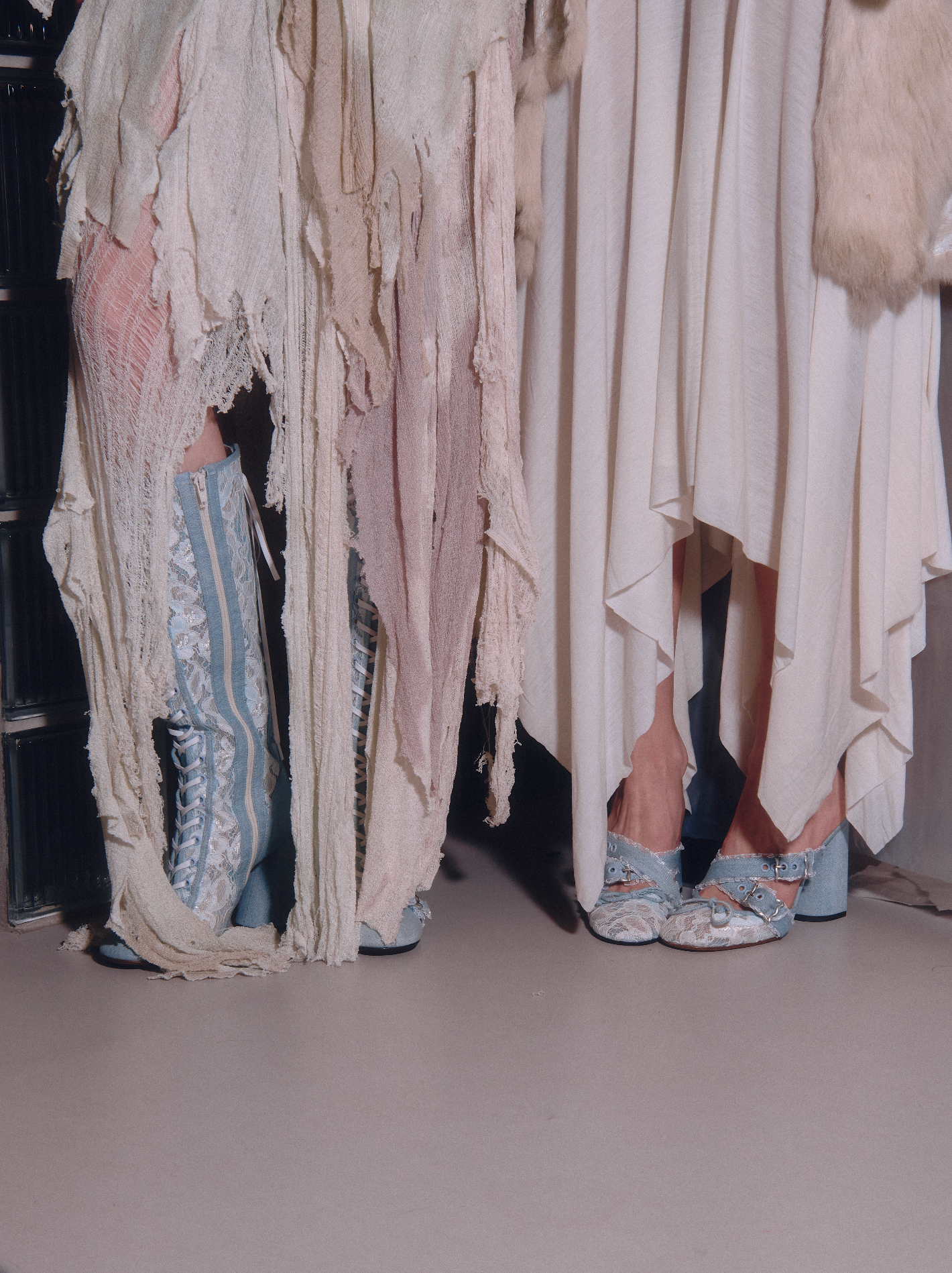 Close-up of a person wearing a textured dress with ruffled details and blue shoes.